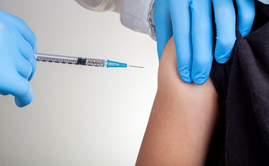 Clinician administering an intramuscular ceftriaxone injection into a patient's upper arm