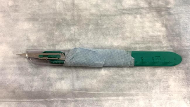 Scalpel with taped cover to avoid too deeply incising the abscess