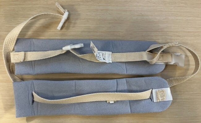 Two Posey soft limb holders laid flat, the materials for an improvised collar and cuff sling